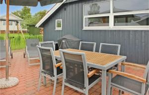 een patio met een houten tafel en stoelen bij Stunning Home In Haderslev With Kitchen in Kelstrup Strand