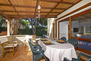 une salle à manger avec une table et des chaises sur une terrasse dans l'établissement Villetta Il Pino, à Punta Ala