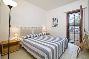 una camera con un letto con una coperta a righe blu e bianche di Villetta Il Pino a Punta Ala