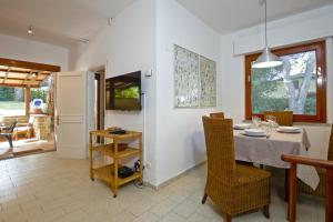 - une salle à manger avec une table et des chaises dans l'établissement Villetta Il Pino, à Punta Ala