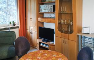 ein Wohnzimmer mit einem TV, einem Tisch und Stühlen in der Unterkunft Nice Apartment In Wernrode With Kitchen in Wernrode