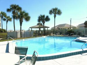 a large swimming pool with chairs and palm trees at Island South 7 in St. Augustine