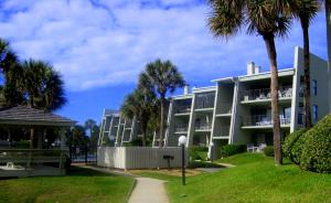 a large apartment building with palm trees and a sidewalk at Island South 7 in Saint Augustine