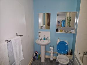 a blue bathroom with a toilet and a sink at Remarkable 1-Bed Apartment in Northampton Town cen in Northampton