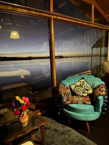 a living room with a chair and a table at Uros Walysuma Titicaca Lodge in Puno