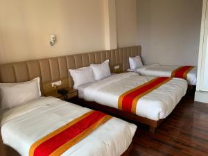 Una cama o camas en una habitación de Redstone Regency Hotel