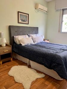 a bedroom with a bed with a blue comforter and a rug at HOTEL MEDITERRANEO in Montevideo