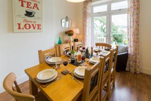 a dining room with a wooden table with chairs and a dining room at Bryn Gwyn & Tegfryn a Pair of Cottages Sea & Mountain Views Borth y Gest in Porthmadog