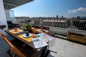 a table on a balcony with a view of a city at Attico36 con parcheggio e vista mozzafiato in Genova