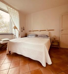 ein Schlafzimmer mit einem großen weißen Bett und einem Fenster in der Unterkunft CHARMING APARTMENT VILLA WITH POOL 010-46-cav-0009 in Rapallo