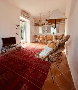 ein Wohnzimmer mit einem Rattanstuhl und einem TV in der Unterkunft CHARMING APARTMENT VILLA WITH POOL 010-46-cav-0009 in Rapallo