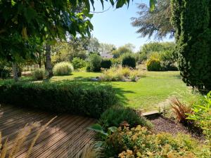 een tuin met een houten terras en groen gras bij chambre hôte avec piscine - La Vialatte in Gaillac