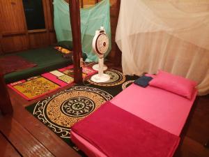 een kamer met een bed en een kamer met een ventilator bij GoodMuning Backpacker in Taliwang