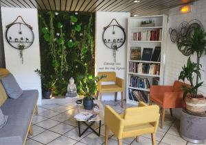 a living room with a couch and chairs and plants at Kyriad Hotel Montpellier Centre Antigone in Montpellier +28 photos