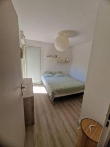 Ένα ή περισσότερα κρεβάτια σε δωμάτιο στο Appartement T2 avec jardin à Saint Gilles Les Bains