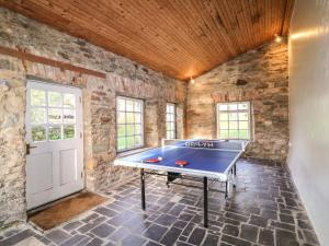a ping pong table in a room with a stone wall at The Ferry House in Ramelton
