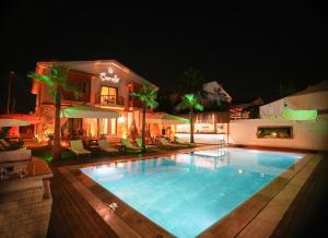 a swimming pool in front of a house at night at Şerefe Hotel Alaçatı in Alaçatı