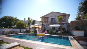 a swimming pool in front of a house at Şerefe Hotel Alaçatı in Alaçatı