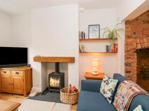 a living room with a blue couch and a fireplace at Bay Tree Cottage in Richmond