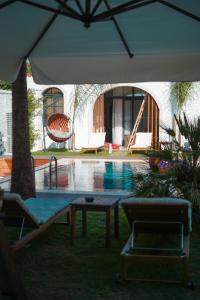 a swimming pool with a table and an umbrella at Şerefe Hotel Alaçatı in Alaçatı +18 photos