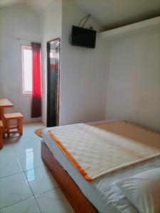 1 dormitorio con 1 cama y TV en la pared en Mozza guest house en Klaten