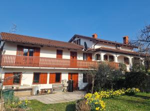 een groot wit huis met oranje deuren en een tuin bij Merlin in Renče