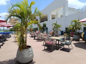 a patio with tables and chairs and palm trees at Skynest Residences by Lisa's Paradise A in Nairobi