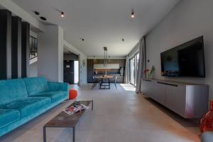 a living room with a blue couch and a flat screen tv at Villa Arestea in Vodnjan