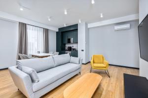 a living room with a couch and a yellow chair at Gratus Aparthotel Tbilisi in Tbilisi City
