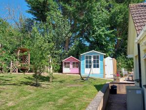 a yard with two smallsheds in the back of a house at Hot Tub Hideaway in Hemyock