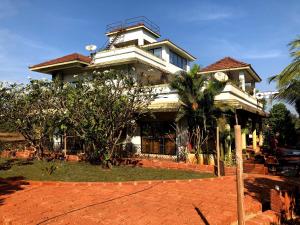 una casa con una palmera delante de ella en Surve Natures Resort - Chiplun, en Chiplun