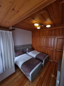 two beds in a room with wooden walls and ceilings at HaciBayramApart in Istanbul