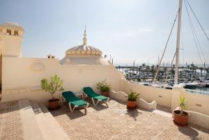 a balcony with two green chairs and a marina at Puerto Marina Luxury Studio in Benalmádena