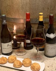 a table with three bottles of wine and three glasses at Nouveau - Maison confortable à Gevrey-Chambertin in Gevrey-Chambertin