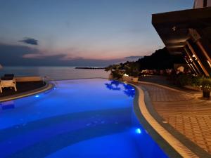 una piscina con vista sull'oceano di notte di SUNSET VIBES DURRËS a Durrës