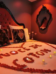 Un letto con il cuore scritto sopra con le candele di O Venus Spa a Sin-le-Noble