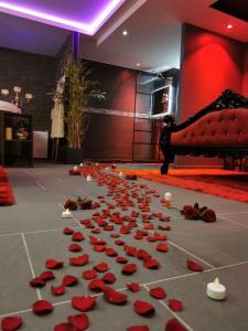 un groupe de roses rouges et de bougies sur un sol dans l'établissement O Venus Spa, à Sin-le-Noble