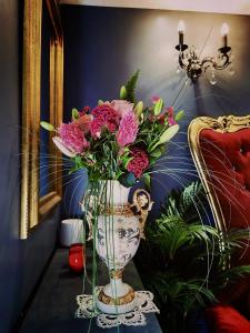 un vaso pieno di fiori rosa su un tavolo di O Venus Spa a Sin-le-Noble