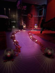 een podium met kaarsen en lichten op de vloer bij O Venus Spa in Sin-le-Noble