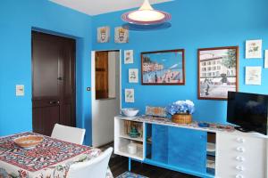 comedor con paredes azules, mesa y sillas en OASI SICILIANA, en Caronia