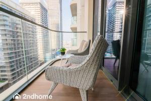 2 Stühle und ein Tisch auf dem Balkon eines Gebäudes in der Unterkunft 2ndhome - Newly Furnished - Marina Vista in Dubai