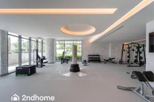 ein großes Zimmer mit einem Fitnessraum mit einer Säule darin in der Unterkunft 2ndhome - Newly Furnished - Marina Vista in Dubai
