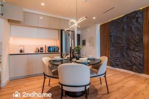 eine Küche und ein Esszimmer mit einem Tisch und Stühlen in der Unterkunft 2ndhome - Newly Furnished - Marina Vista in Dubai