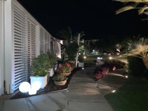 a walkway with potted plants and lights at night at Cala Rosa Club Hotel in Stintino