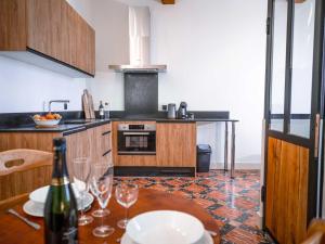 una cocina con una mesa con copas de vino. en Les Bastides de Roquemaure, 
