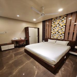 1 dormitorio con 1 cama blanca grande y escritorio en The Mint Nanded Hotel, en Nanded