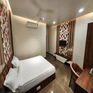 a bedroom with a bed and a table and a desk at The Mint Nanded Hotel in Nānded