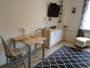 Una sala de estar con una mesa y sillas y un televisor. en Studio w centrum Starego Miasta, en Olsztyn