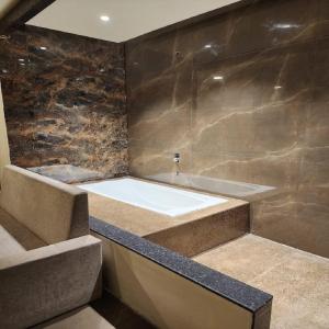 a bathroom with a bath tub and a sink at The Mint Nanded Hotel in Nānded