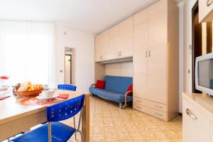 a kitchen with a table and blue chairs in a room at Tivoli in Bibione